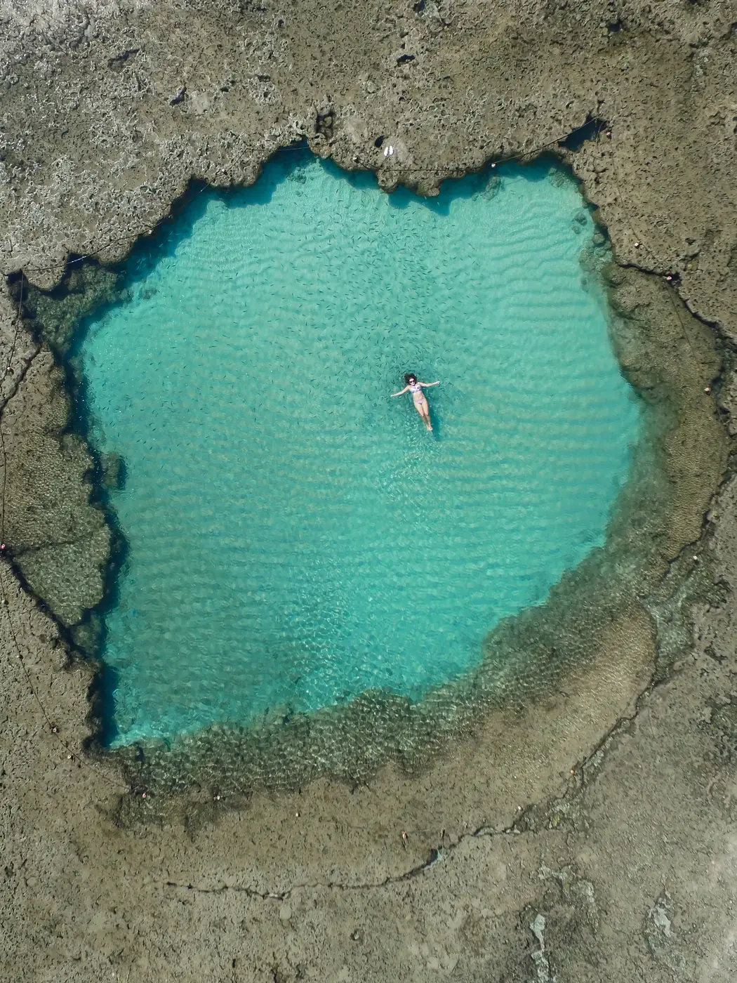 Vista aérea da praia de Porto de Galinhas com jangadas coloridas ancoradas sobre os recifes