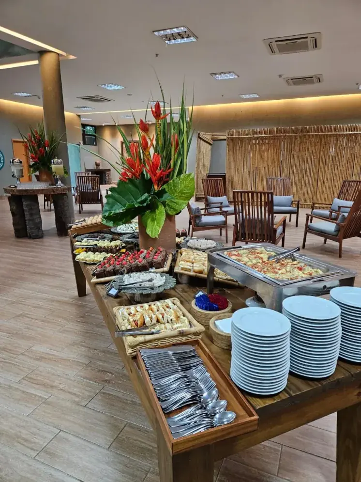 Buffet de coffee break com doces, salgados e pratos quentes no foyer do resort