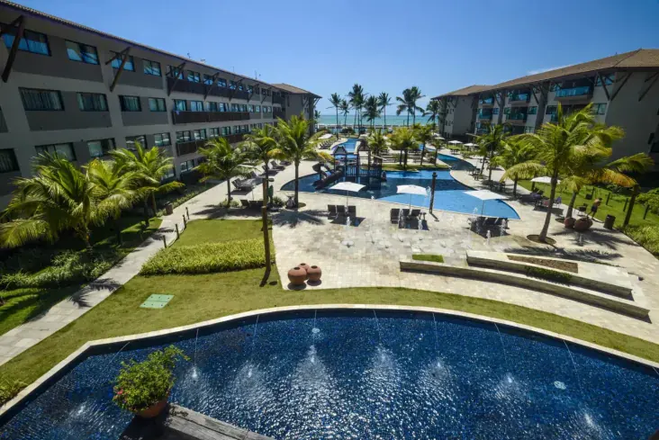 Parque de piscinas interligadas do Samoa Beach Resort, com brinquedo aquático e vista para o mar