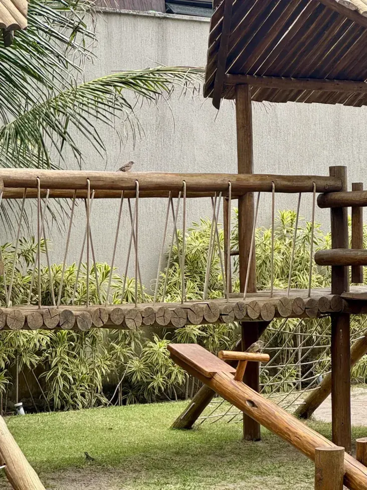 Parquinho infantil de madeira entre os jardins do Samoa Beach Resort