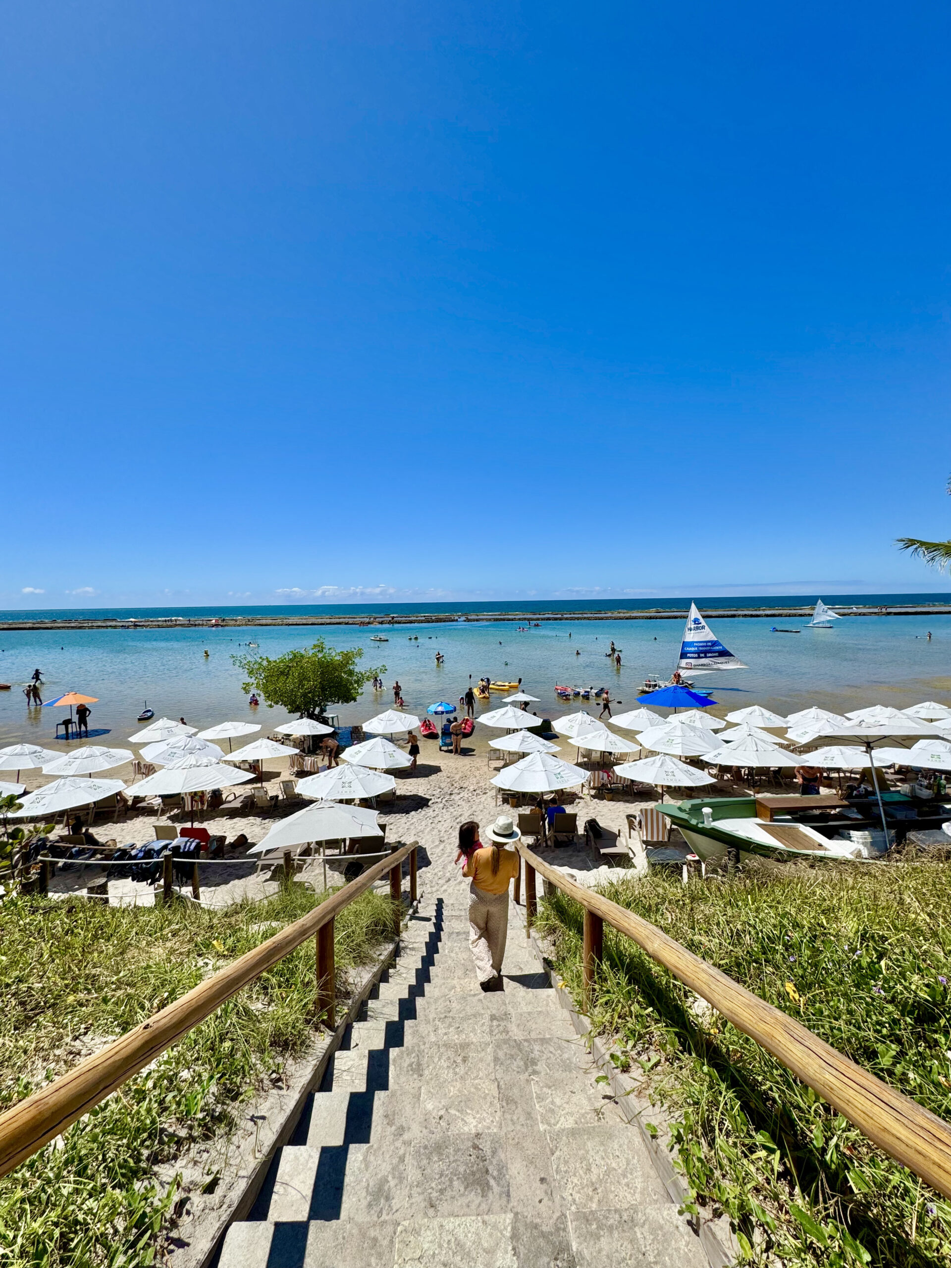 faixa de praia de Muro Alto com a barreira de recifes ao fundo e a estrutura do resort em primeiro plano.